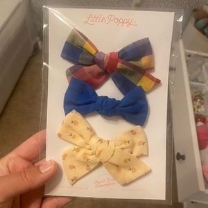 Never opened little poppy bow set